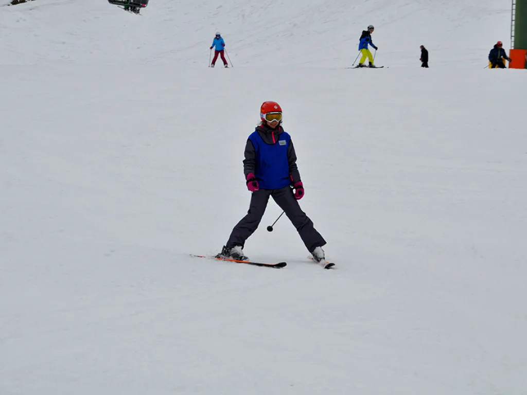 Skifahrer auf der Piste, oben weitere Fahrende.